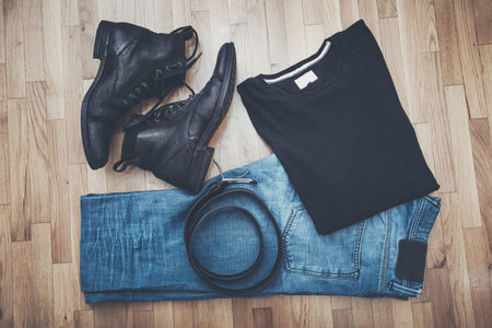 men black leather shoes and blue worn jeans, t-shirt and belt on parquet from above