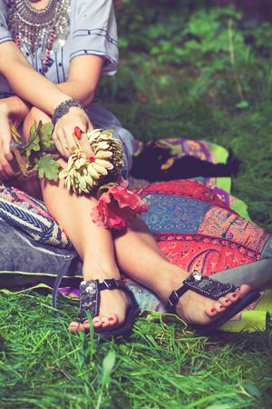 summer boho style fashion woman sit in garden holding silk flowers in hands closeupの写真素材