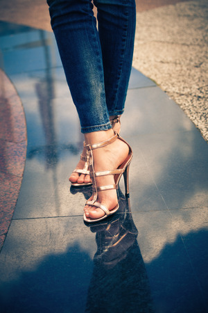 woman legs in high heel sandals stand on marble pavementの写真素材