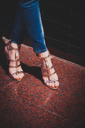 woman legs in golden summer high heel sandals outdoor summer day in the cityの写真素材