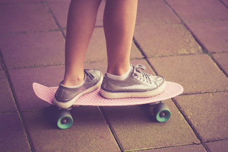 teen girl in sneakers on skate closeup outdoor on street