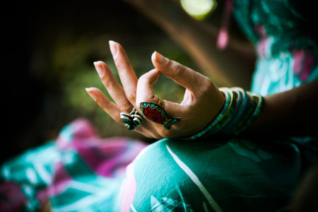 closeup of woman hand with rings and bracelets practice yoga outdoor shot
