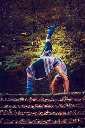 young woman practice yoga outdoor autumn day in parkの写真素材
