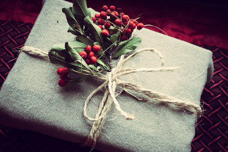New Year gift wrapped in natural material with twigs with berries