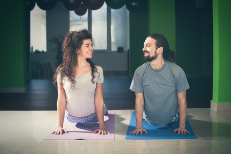 smiling young man and woman doing yoga  indoor healthy lifestyle conceptの写真素材