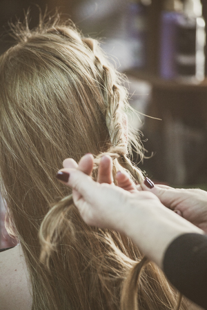 woman making braids at hair studio closeupの写真素材