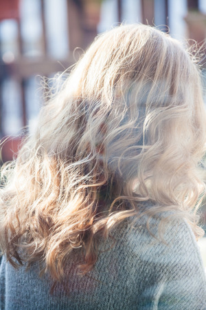 beautiful blonde wavy hair woman portrait outdoor through windowの写真素材