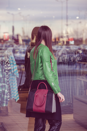 young fashionable urban girl looking in shop windowsの写真素材