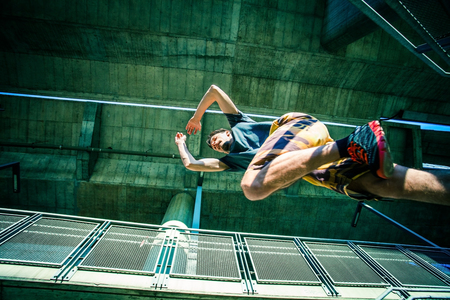 young man practice parkour jump on stairs  in the city extreme sport concept shot from from belowの写真素材