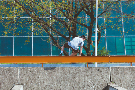 young man doing parkour in urban space in the city  suuny spring summer day 
の写真素材
