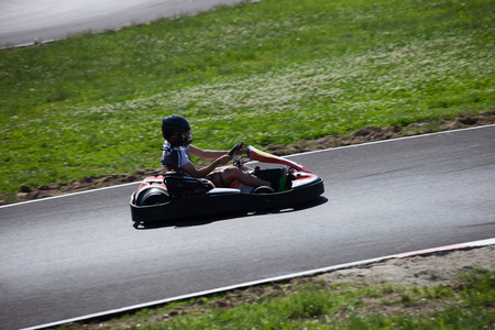 young man drive go kart on track side view outdoor shotの写真素材