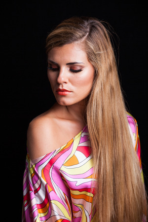 beauty young blonde woman portrait in colorful silky dress with very long hairの写真素材