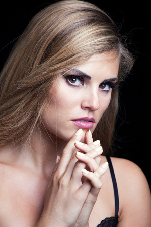 beauty portrait of blonde girl with sparkly eye shadow long hair studio shotの写真素材