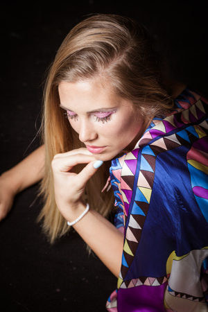 beauty young blonde woman portrait in colorful silky dress with interesting  makeup  crystals studio shotの写真素材