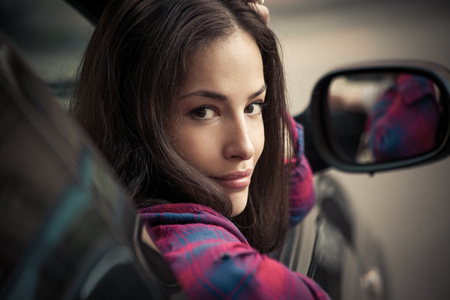 young woman in car look trough window and smileの写真素材
