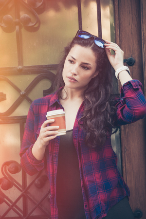young woman with  coffee to go outdoor portrait in the cityの写真素材