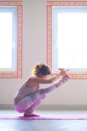 young woman practice yoga indoor full body shot side viewの写真素材