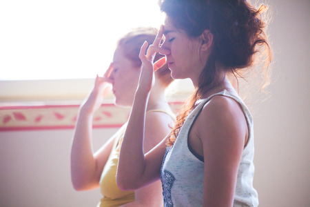 Closeup of couple of women on yoga class exercises breathing technique healthy lifestyle concept indoorの写真素材