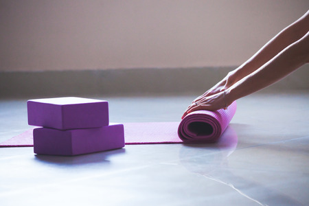woman rolling yoga mat indoor shot natural  light closeupの写真素材