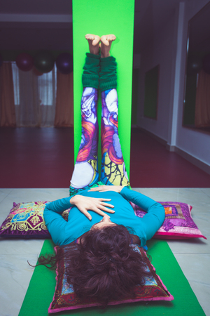 young woman in yoga relaxing pose with legs up the wall  indoorの写真素材