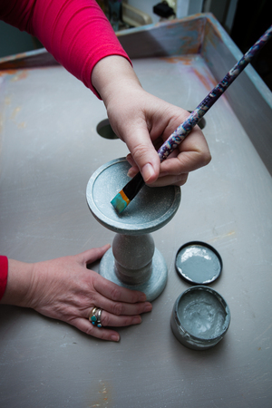 woman hands with brush paint with chalky paint wooden candlestick  from above viewの写真素材