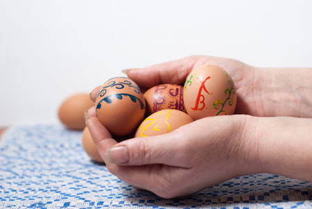 Female hands holding a painted colored Easter eggsの写真素材