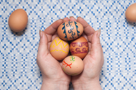Female hands holding a painted colored Easter eggsの写真素材