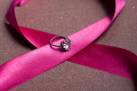 Beautiful pink ribbon with a ring, greetings on happy women's day