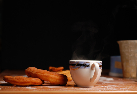 mug of hot tea with doughnuts on a black backgroundの写真素材