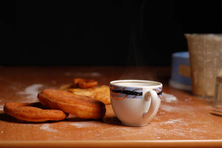 mug of hot tea with doughnuts on a black backgroundの写真素材