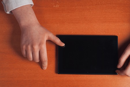 The girl working with digital tablet on wooden tableの写真素材