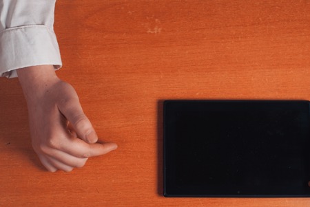 The girl working with digital tablet on wooden tableの写真素材