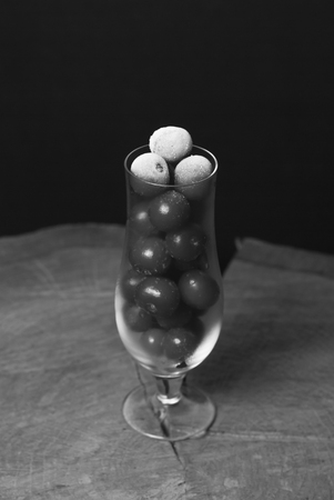 Frozen cherry in the wine glass, chilled berry on wooden tableの写真素材