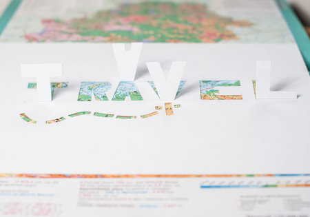 The word travel cut from paper, a stencil from white paperの写真素材