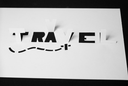 The word travel cut from paper, a stencil from white paperの写真素材