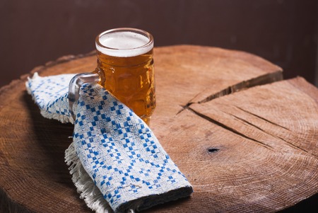 The Oktoberfest Grounds. Beer on a wooden table, a towel with the pattern of the Bavarian flagの写真素材