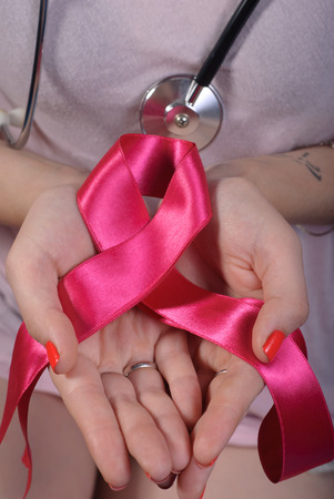 close up of a girl holding in the palm of pink silk ribbon, the concept of the fight against breast cancerの写真素材