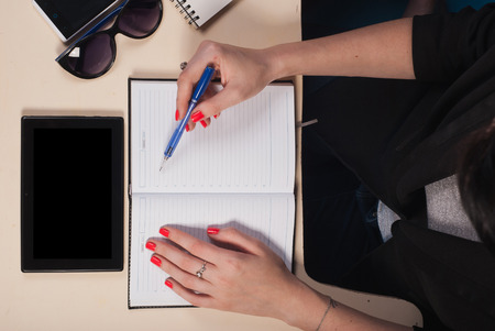 Businessman working behind a Desk with a tablet, documents and other objects around, top viewの写真素材