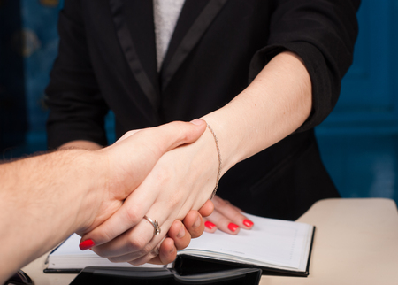 Shaking hands with client in office, closeup, conclusion, contract, concept business womanの写真素材