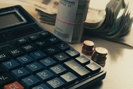 Money concept. Calculator with coins lie on the desktop, closeupの写真素材