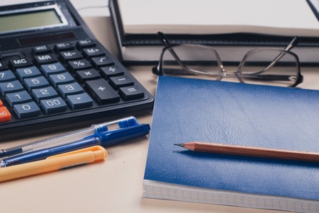 glasses, calculator, Notepad on a white table. Business concept accessories.の写真素材