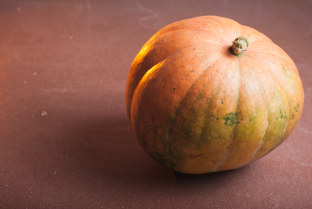 One orange pumpkin on a wooden table, happy holidaysの写真素材