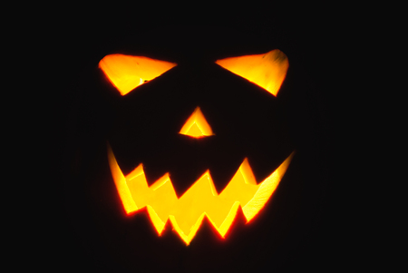 Halloween Jack-o-lantern on a black background, pumpkin with glowing in the dark eyes, the horror on Halloweenの写真素材