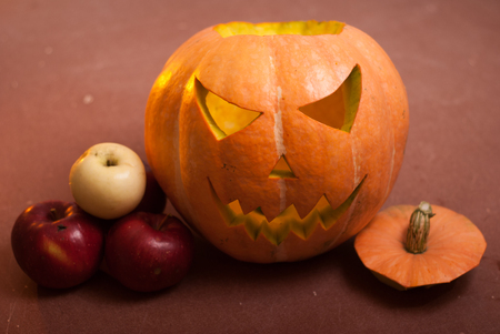 Autumn arrangement of pumpkins and apples, a pumpkin-lantern on a wooden table, happy Halloweenの写真素材