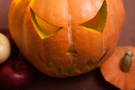 Autumn arrangement of pumpkins and apples, a pumpkin-lantern on a wooden table, happy Halloweenの写真素材