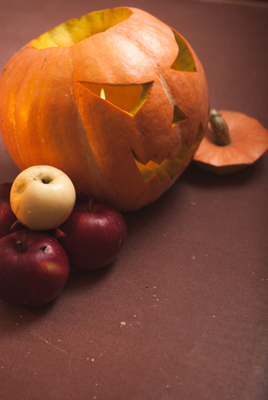 Autumn arrangement of pumpkins and apples, a pumpkin-lantern on a wooden table, happy Halloweenの写真素材