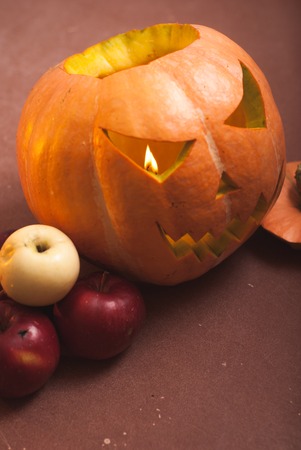 Autumn arrangement of pumpkins and apples, a pumpkin-lantern on a wooden table, happy Halloweenの写真素材