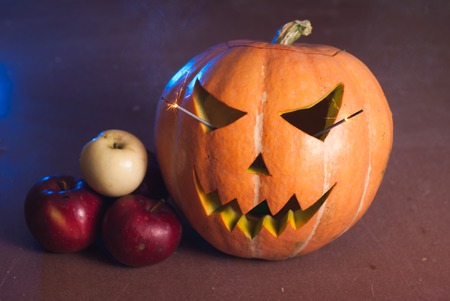 Autumn arrangement of pumpkins and apples, a pumpkin-lantern on a wooden table, happy Halloweenの写真素材