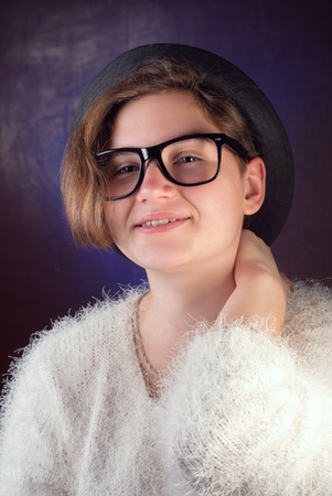 Young cute girl in a hat and sunglasses, a teenage girl posing for the camera, fashion accessories, hipsterの写真素材