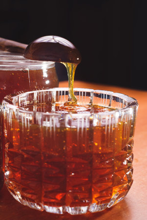 Honey drip in jar on dark, solatedの写真素材